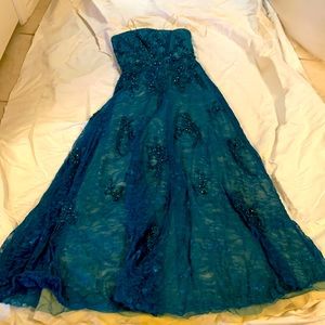 Gorgeous teal evening gown with beautiful beading .